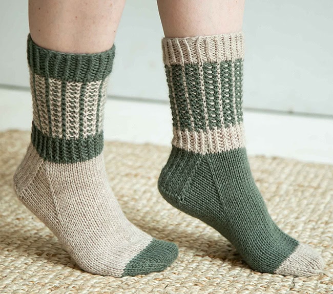 A side view of the socks, still on feet, showing the heel flap and gusset.