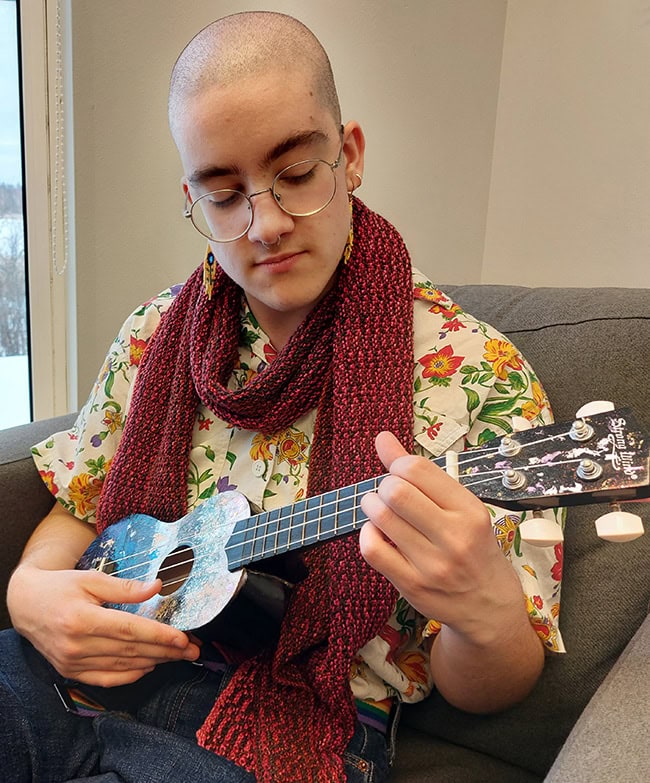 A closeup of the person and scarf, showing the color pattern and stitch pattern.