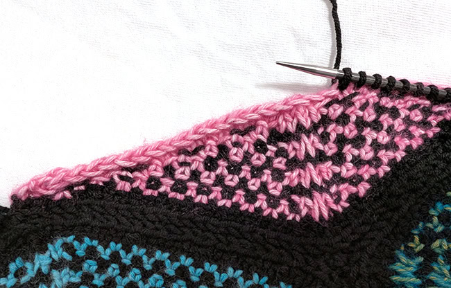 A closeup image of stitches being picked up in black from a Hexagon Edge.