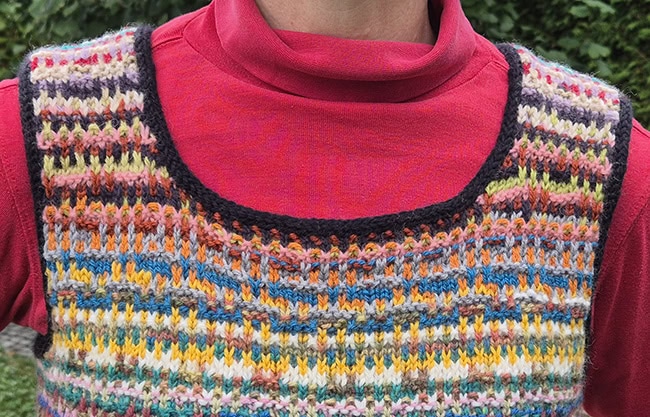 A closeup of the top of the square neck vest, focused on the i-cord edging.